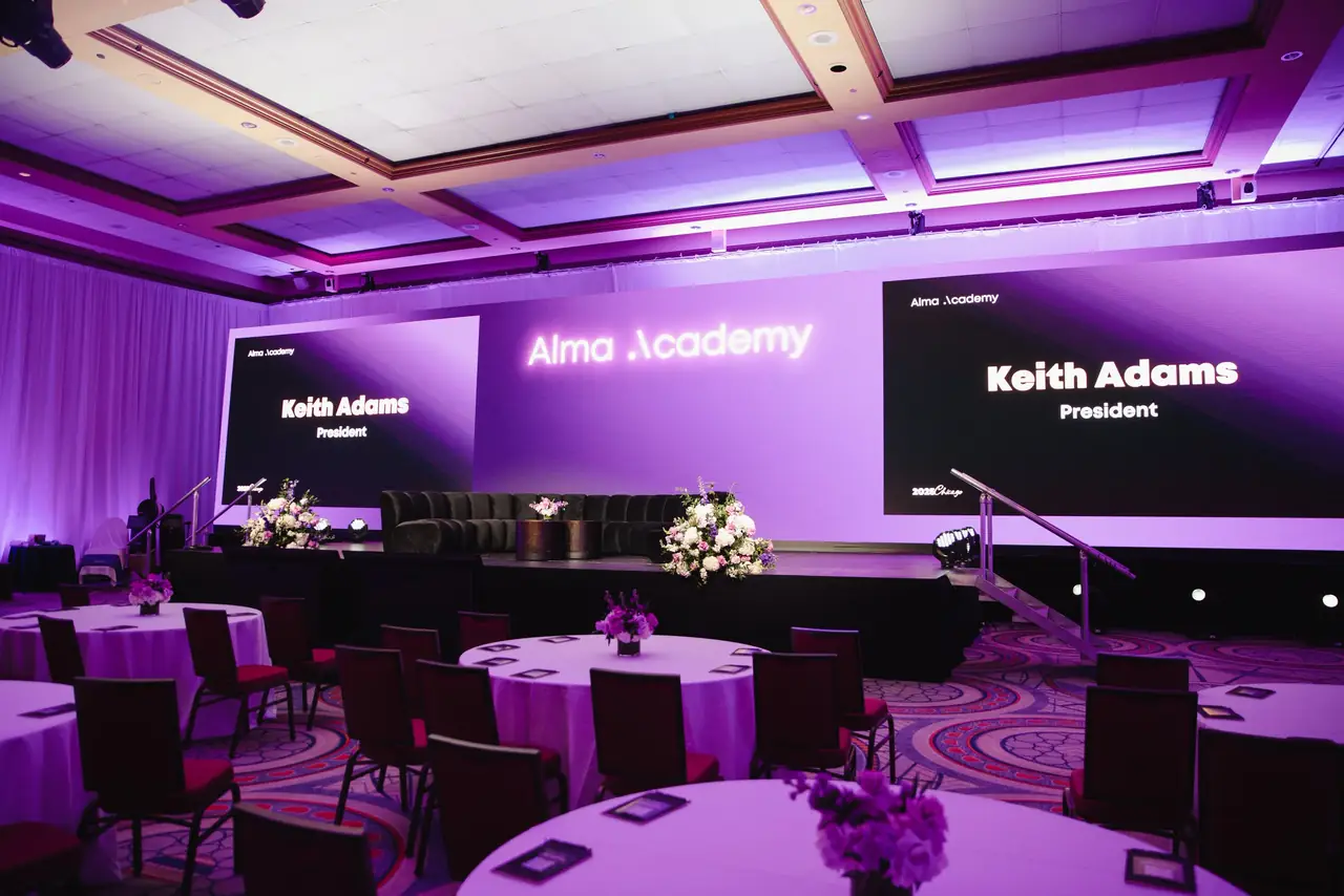 Alma Academy ballroom: Alma Academy on the centre screen, Keith Adams on the side screens, purple uplight