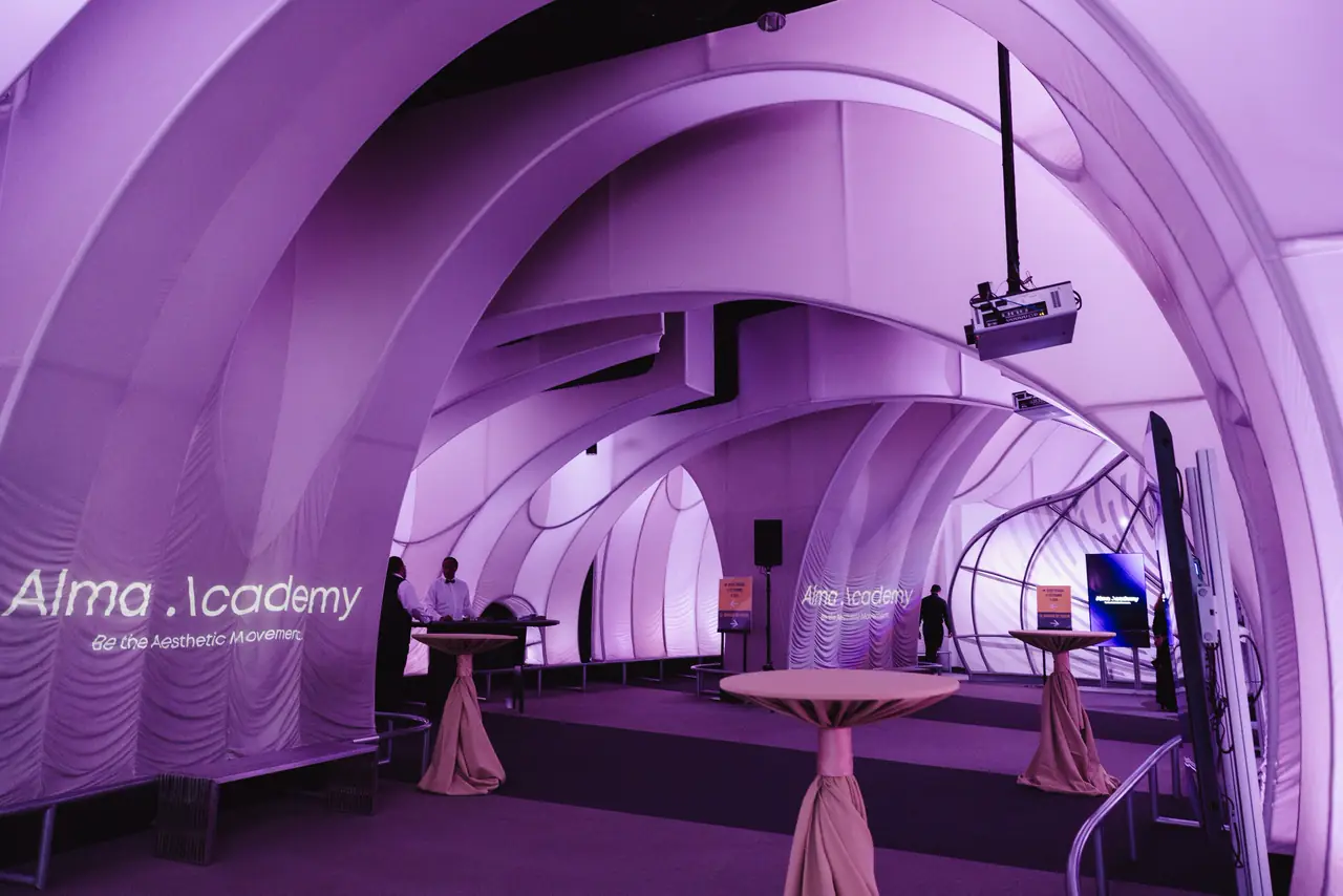 Alma Academy branding projected inside a white domed planetarium space