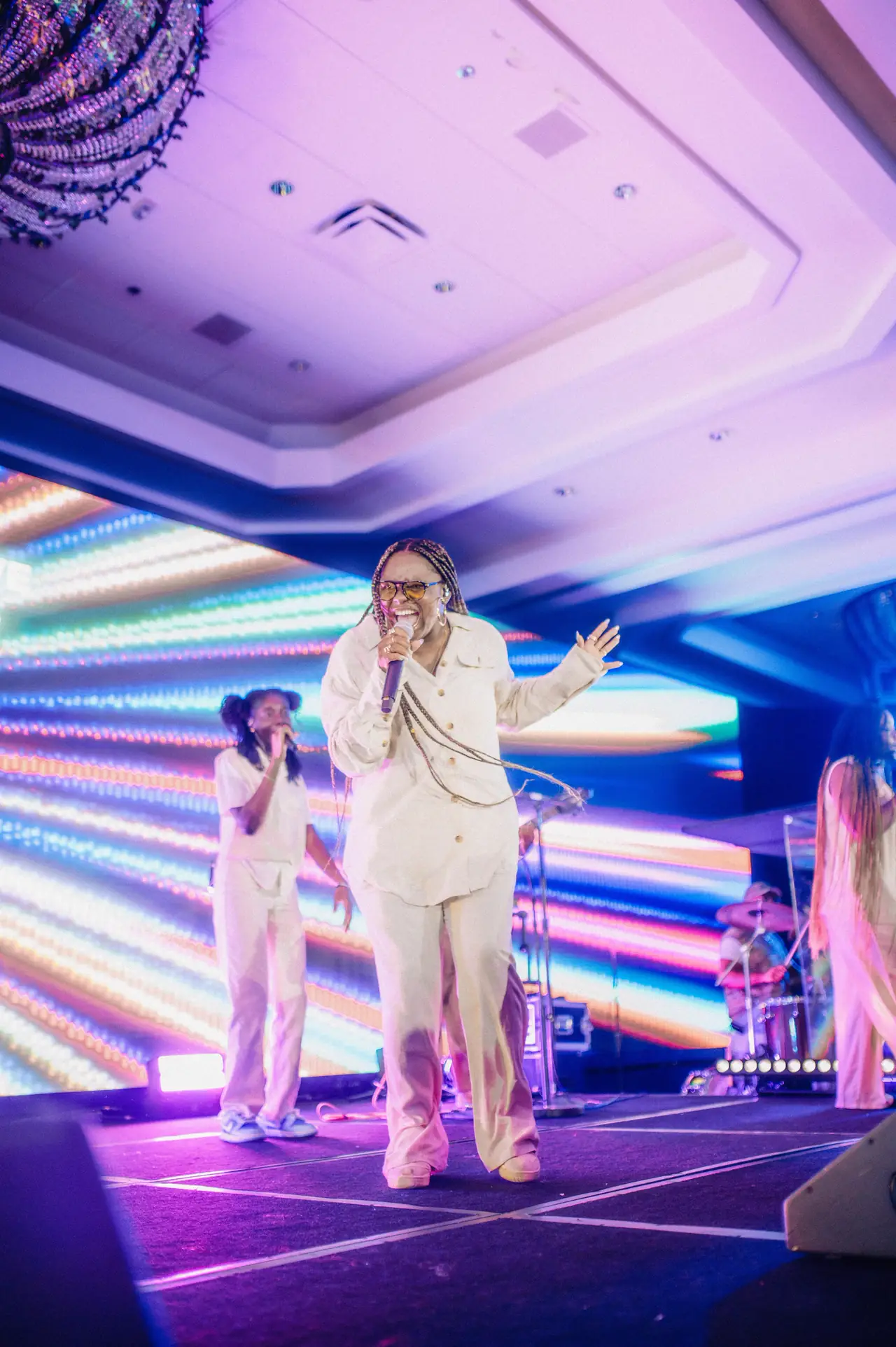 Worship leaders on a stage framed by colorful LED panels