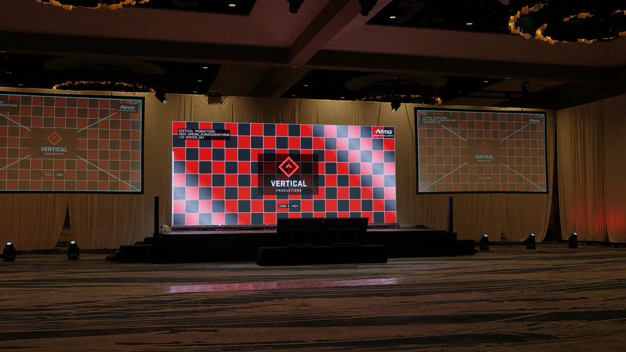 Load-in: the LED wall and side screens up on a Vertical Productions test raster in an empty ballroom