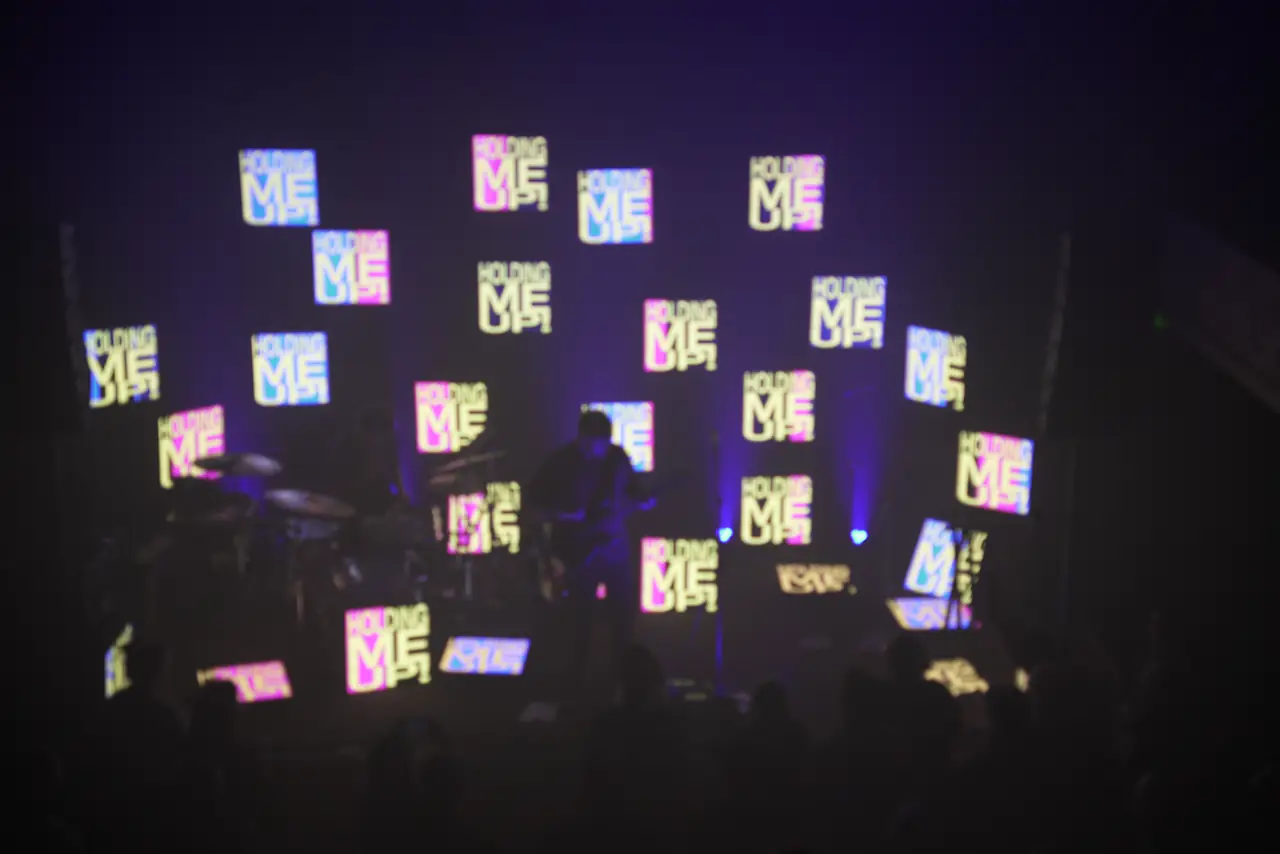 Stephen Stanley on stage in front of a scattered field of LED panels