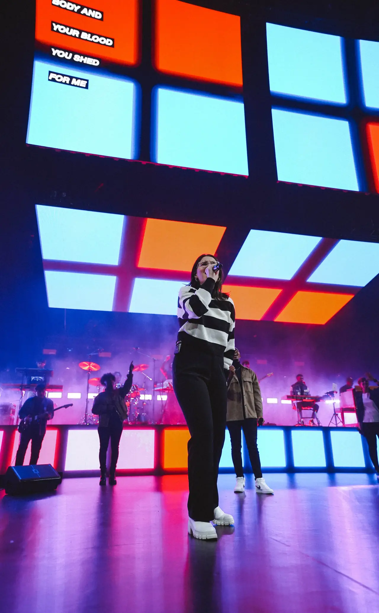Speaker in front of a tall LED wall split into red, white and blue panels