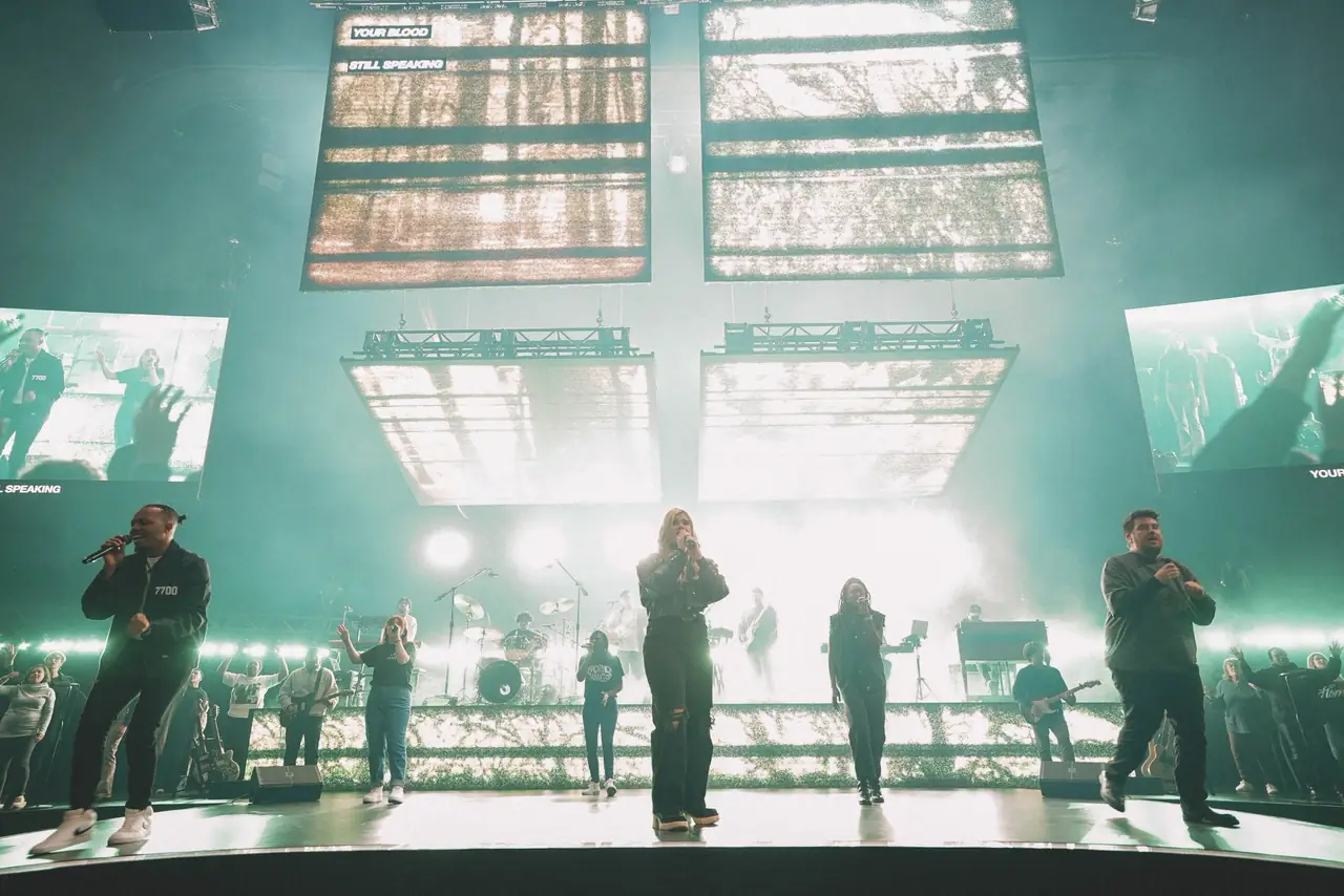 Victory Conference stage in teal light with suspended LED panels above the worship team